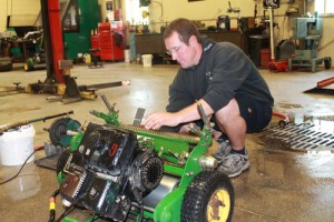 Kevin Jacky, equipment technician at Whistling Straits, tunes up a John Deere greens mower (while wearing a Blackwolf Run sweater.)