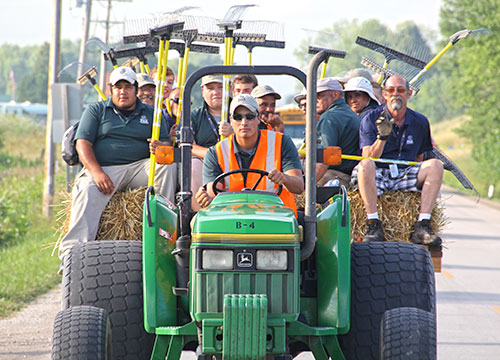 The bunker raking crew gets a ride to the far south end of the course.