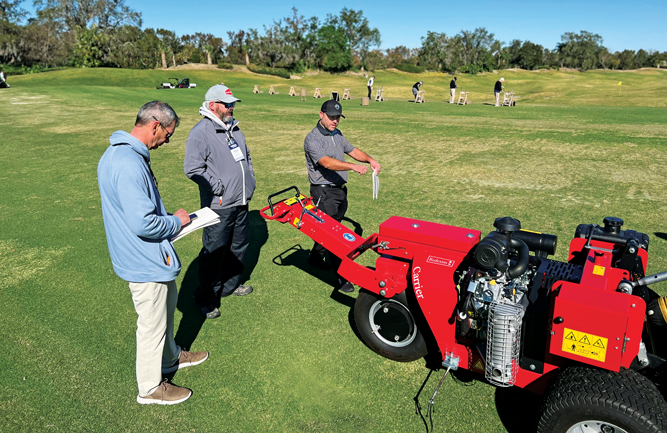 Brad Lackey (center), Redexim, walks TJ Winzeler (left), Corte Bella GC, and Matthew Bilson, Promontory Club, through the features
of the Verti-Drain. (Photo: Golfdom staff)