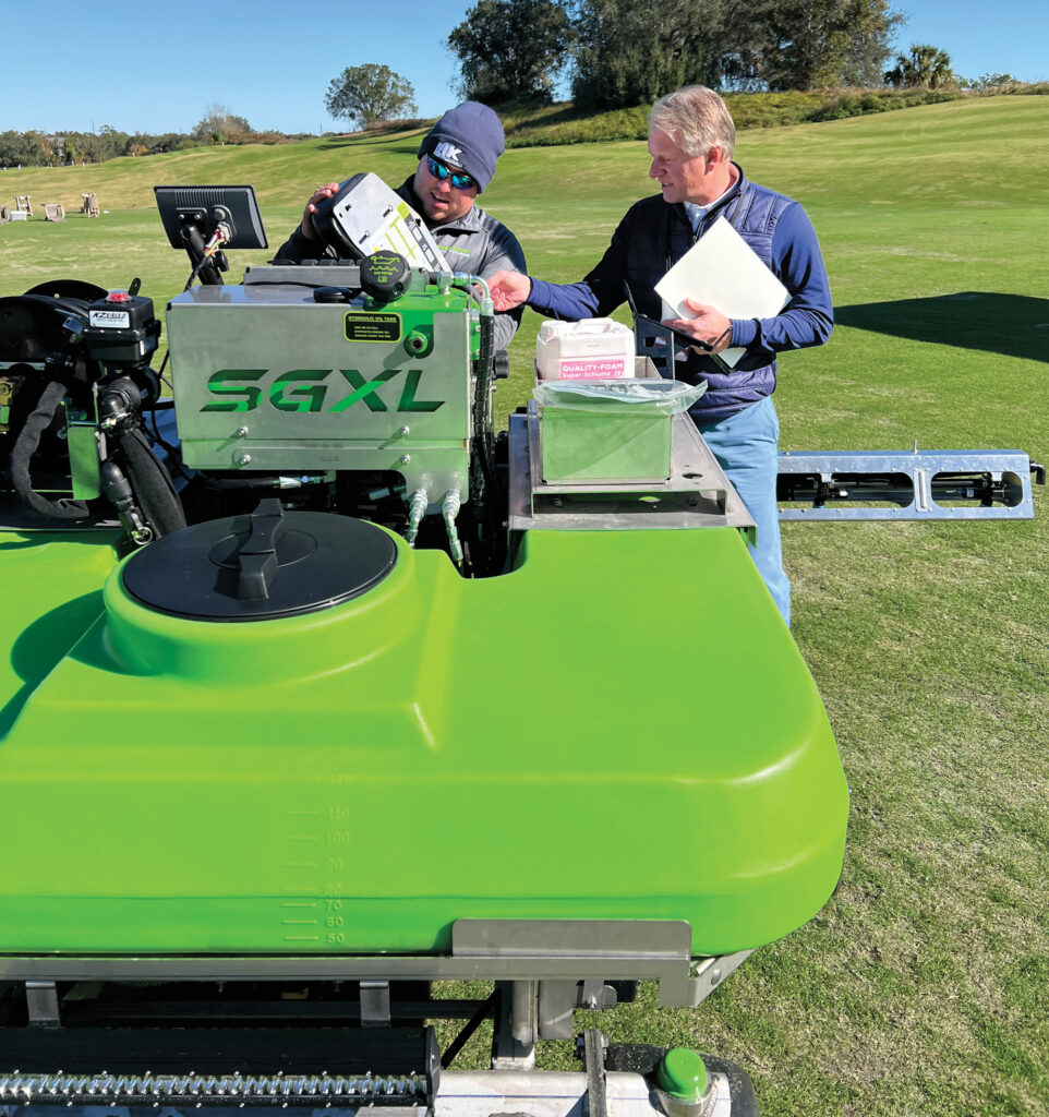 Caleb Myers, sales representative, Steel Green Manufacturing, shows Scott Bower, Martis Camp Club, Truckee, Calif., the company’s ride-on spreader/sprayer. (Photo: Golfdom staff)